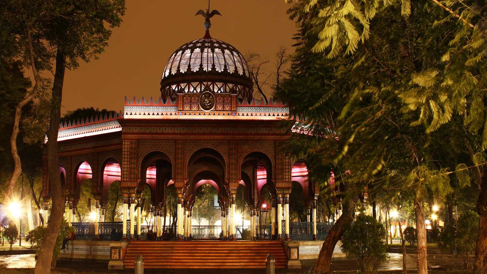 Perspectiva completa de la magnífica estructura de hierro del Kiosko Morisco bajo un cielo luminoso en Santa María la Ribera.