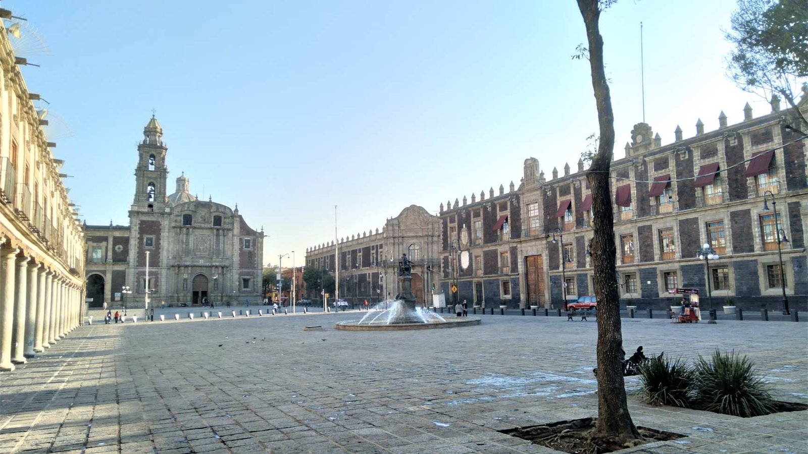 Vista de la histórica Plaza de Santo Domingo con sus portales coloniales bajo un cielo claro en la Ciudad de México.