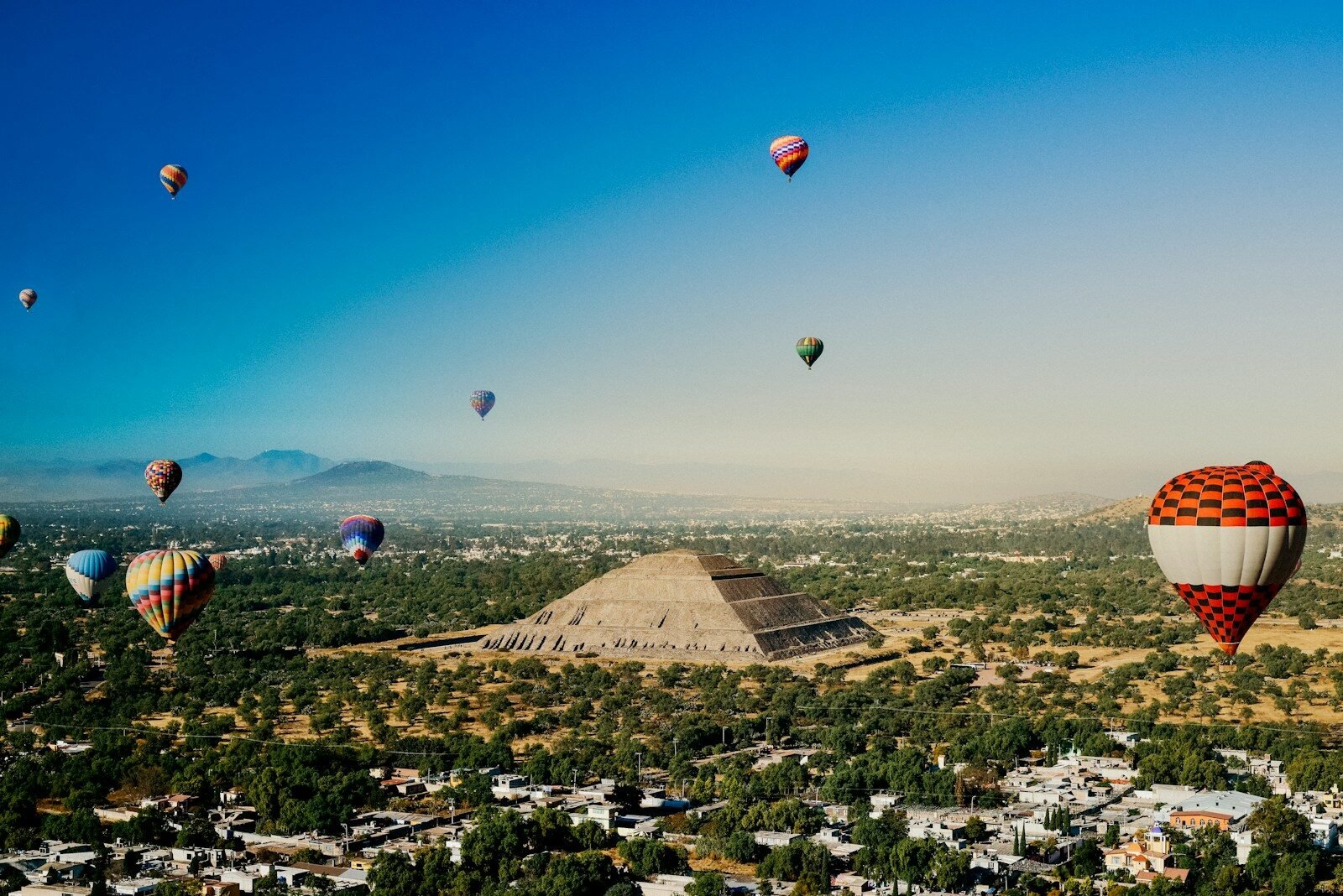 a group of hot air balloons flying over a city